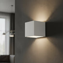 Applique cubica in gesso verniciabile con luce up and down installata su parete moderna 