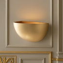 applique in gesso decorata con foglia oro e luce indiretta verso l’alto per ambienti eleganti