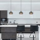 Lampadario Maxy Ø29 cm nero con coppa in vetro fumé su un'isola di una cucina moderna