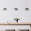 Lampadario Maxy nero con coppa in vetro fumé trasparente su un tavolo da cucina