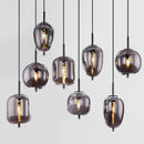 sospensione lineare con otto diffusori in vetro trasparente grigio di forme diverse