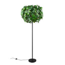 Lampada da terra LEAVY con foglie verdi in plastica e base in metallo nero opaco.
