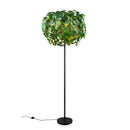 Lampada da terra LEAVY by Trio Lighting con foglie verdi in plastica e base in metallo nero opaco.