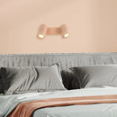 Lampada rosa con 2 faretti orientabili a parete in una camera da letto
