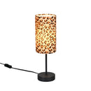 Lampada da tavolo Pardina con paralume cilindrico in tessuto leopardato animalier e base nera